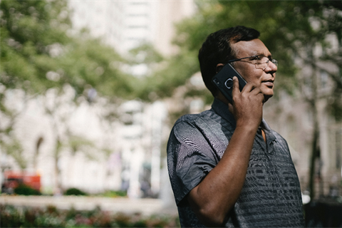 man outside looking into the distance talking on a mobile phone